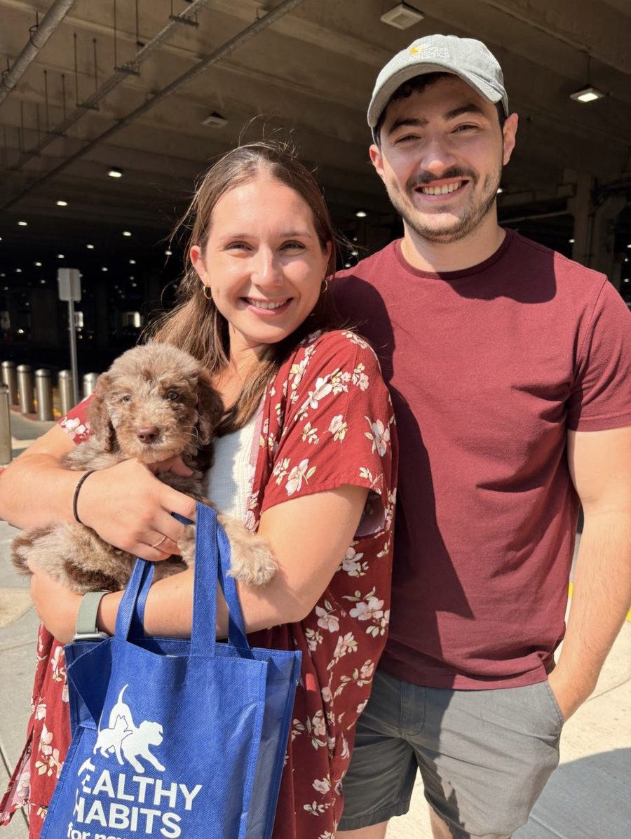 Happy couple with their doodle puppy after a flight nanny delivery